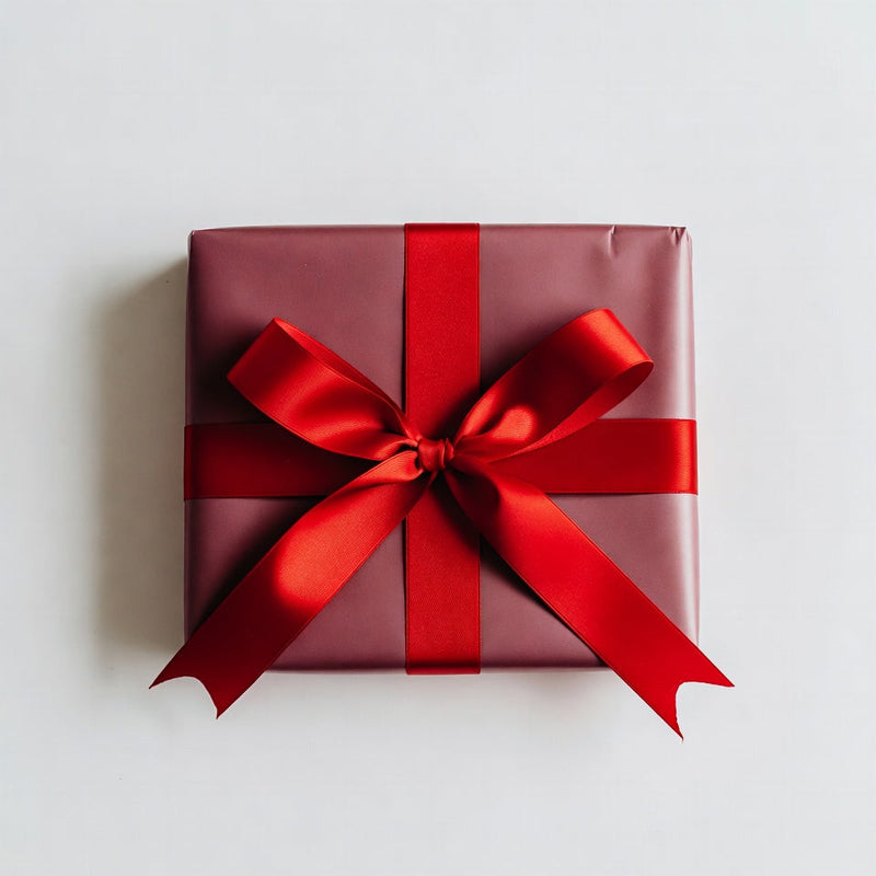 Red gift box with a large red bow on a light gray background